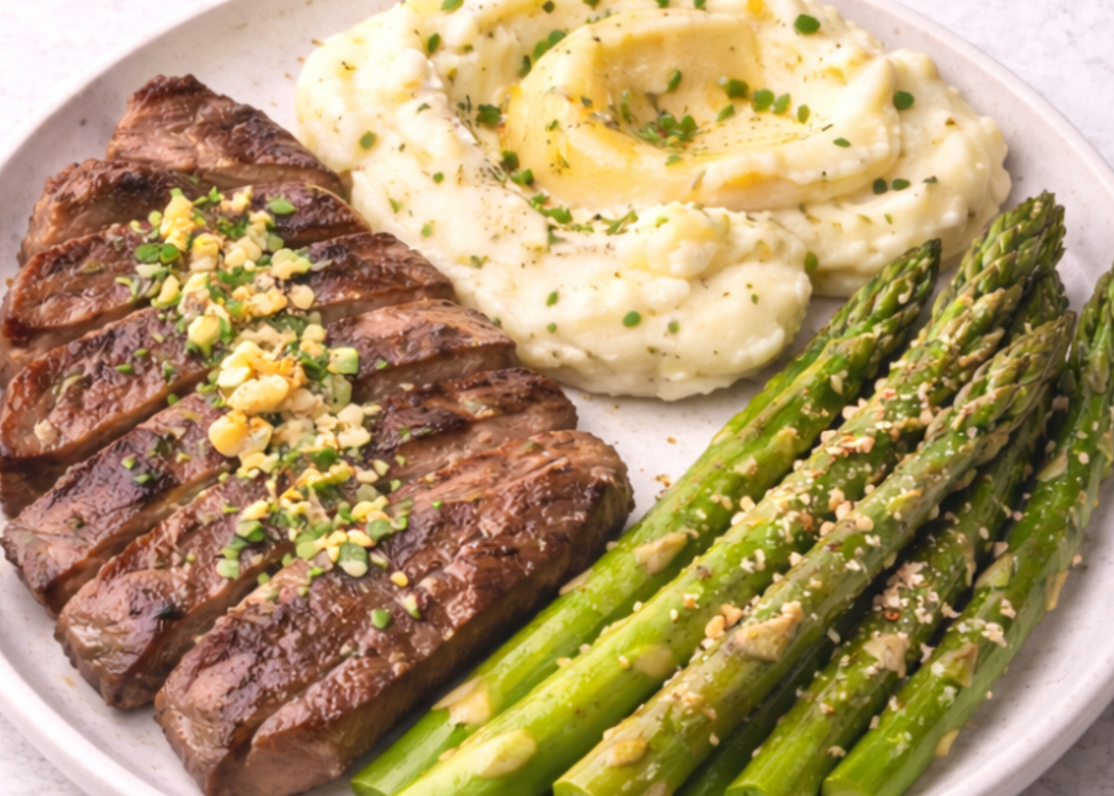 Steak, mashed potatoes, and asparagus showing a balanced meal including protein, carbs and fat.